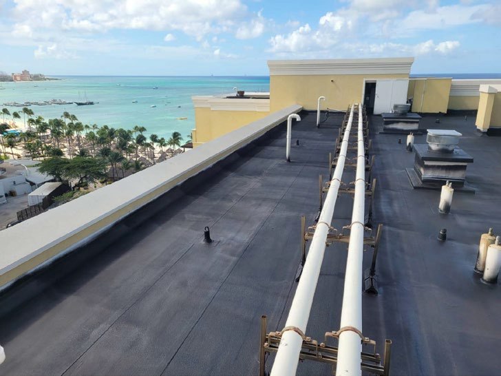 Neptune Coatings crew applying a WetSuit membrane to a coastal building roof